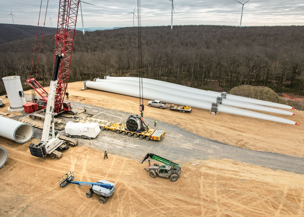 Aerial view of crane setting wind turbine component onto Goldhofer trailer