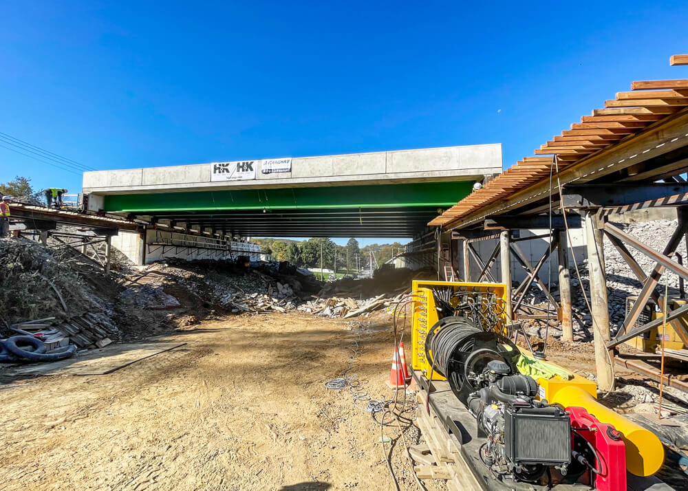 A Buckingham unified jacking machine sits in foreground of newly installed bridge on I-476