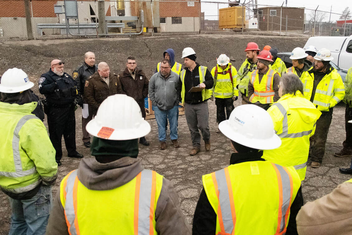 Buckingham personnel and other site workers hold an onsite meeting before starting work