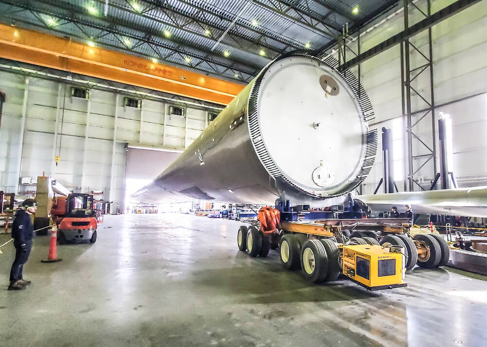 A Buckingham dolly transporter with SmartSteer® moves a wind turbine blade into a testing facility