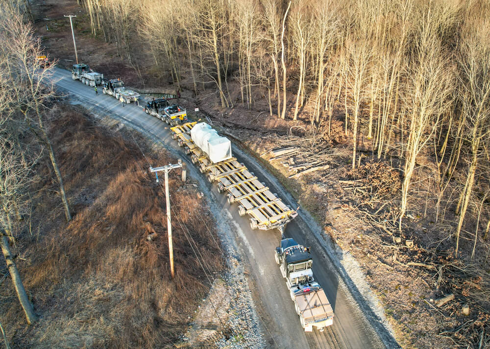 Aerial view of Buckingham Transport's trucks and Goldhofer delivering a wind turbine component on a mountainous road