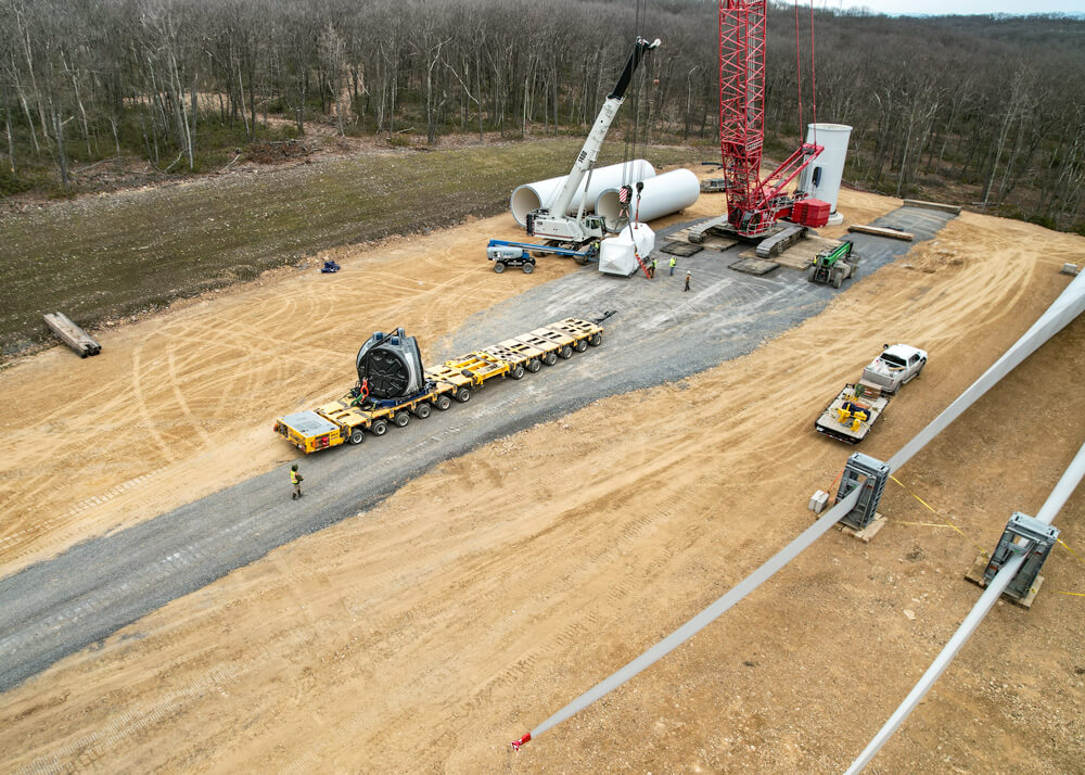 Aerial view of wind turbine site and Goldhofer trailer loaded with wind turbine component 