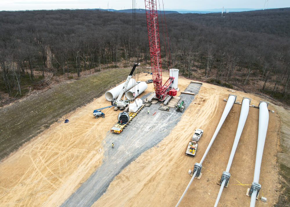 Aerial view of crane loading a trailer for Buckingham Transport with wind turbine blades in foreground
